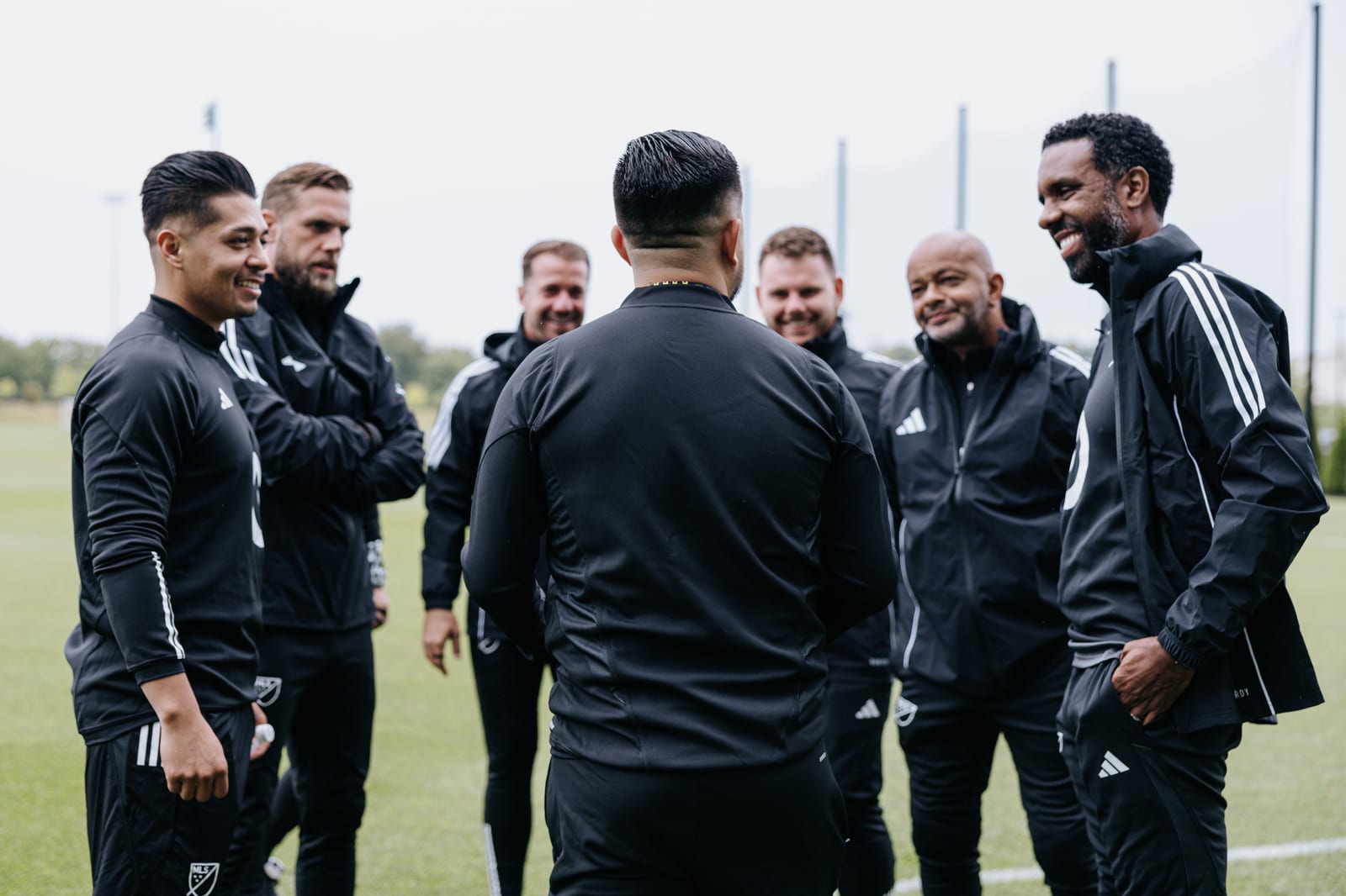 Luis in discussion with a group of coaches